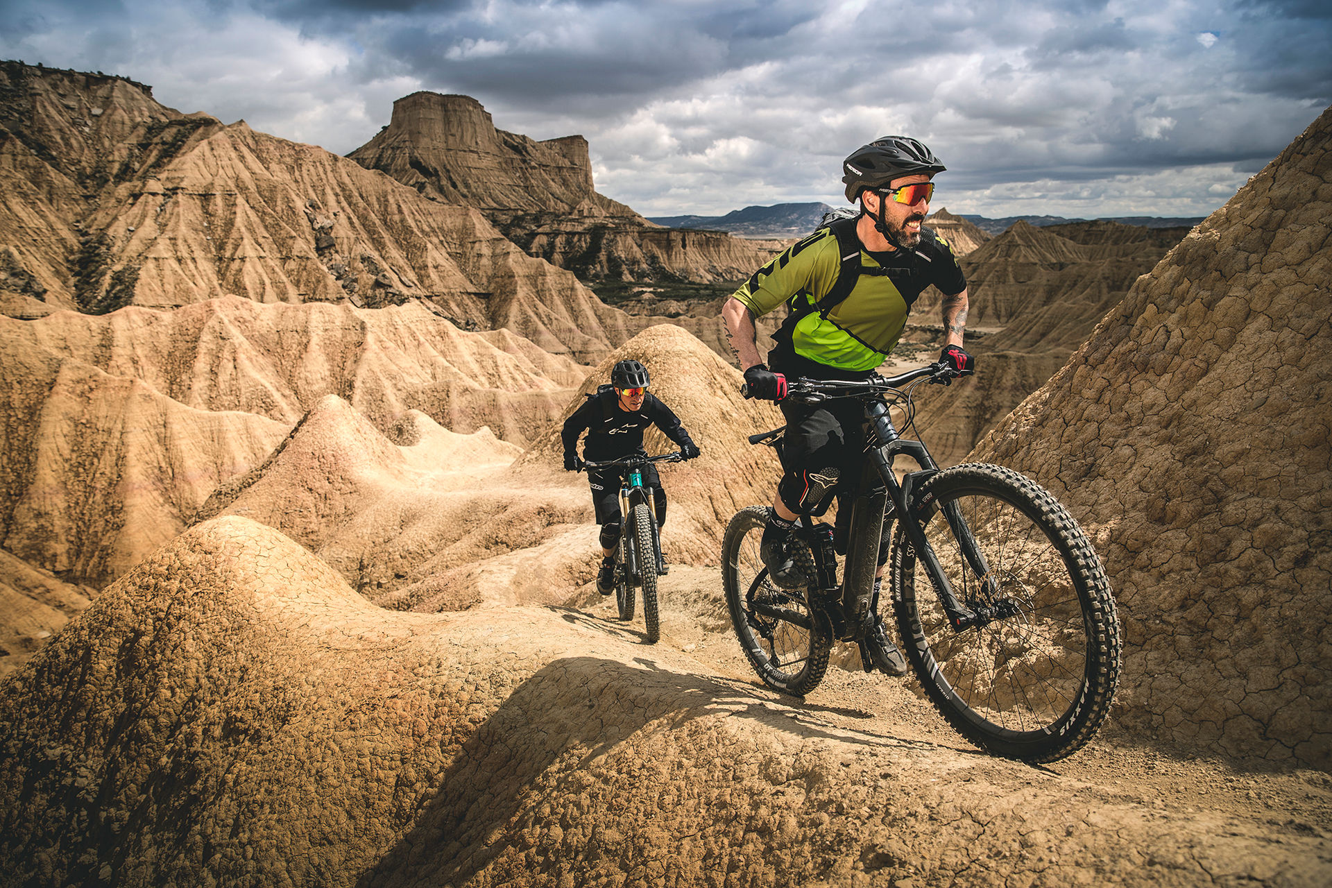 Two helmeted riders exploring a rugged trail on Merida electric mountain bikes